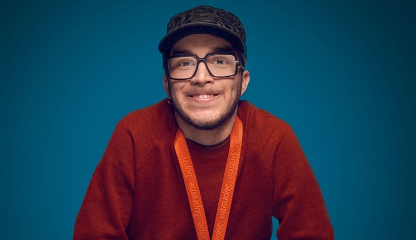 A man wearing glasses and an orange lanyard.