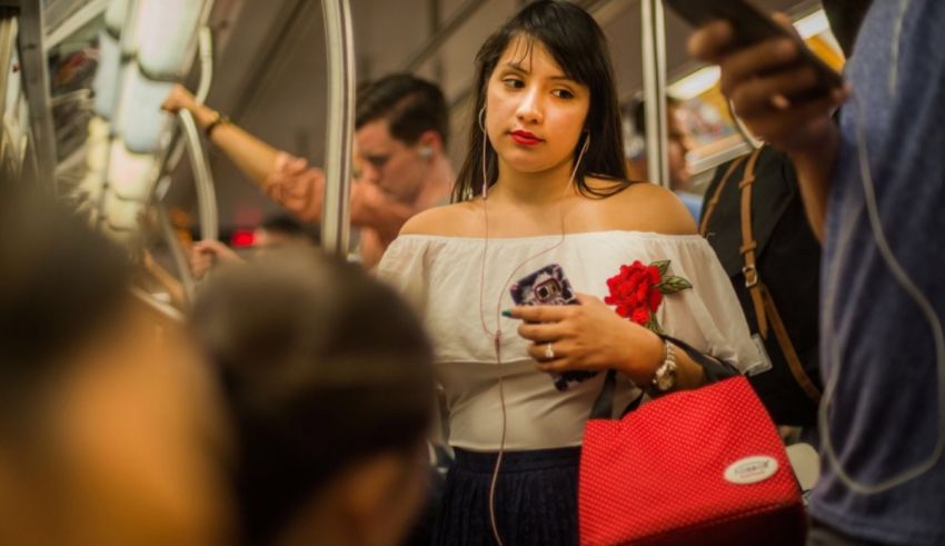 A woman on a subway looking at her phone.