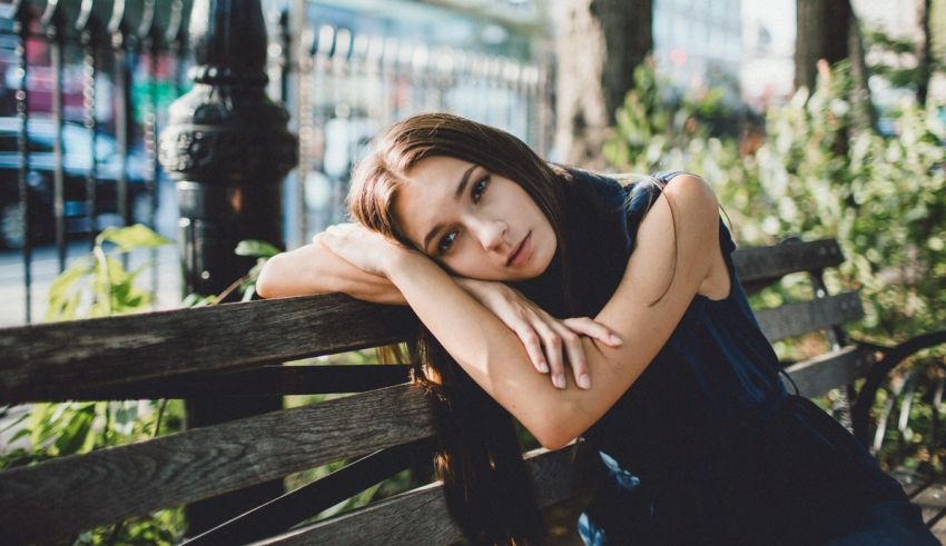 A young woman leaning on a park bench.
