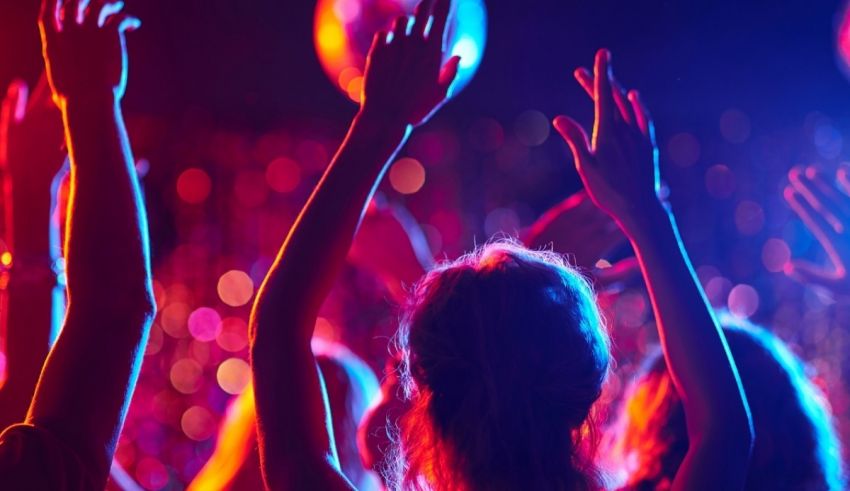 A group of people with their hands up at a party.