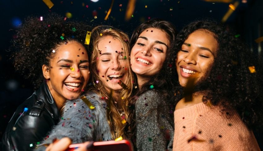 A group of friends taking a selfie with confetti.