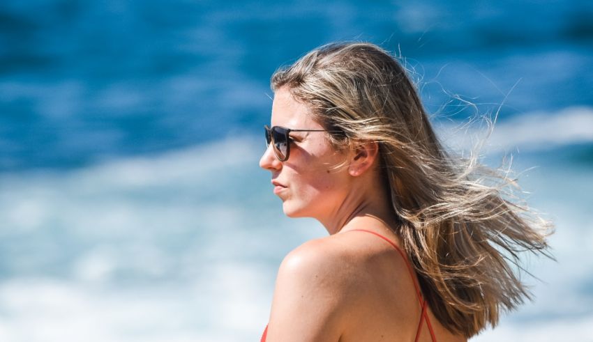 A woman in a red bikini standing on the beach.