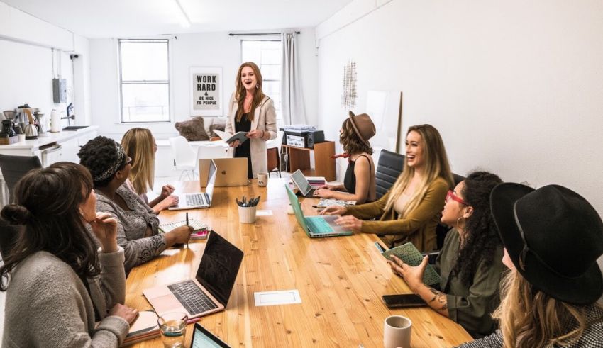 A group of women sitting around a table with laptops.