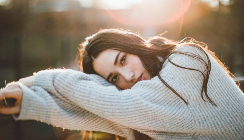 A woman in a sweater leaning against a railing.