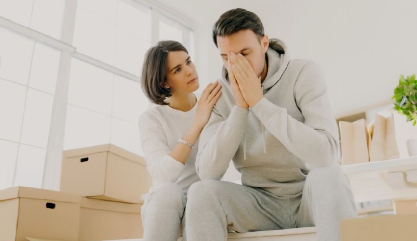 A man and woman sitting on the floor with boxes in front of them.
