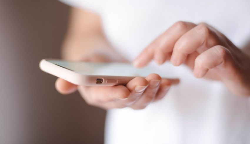 A woman's hand is holding a cell phone.