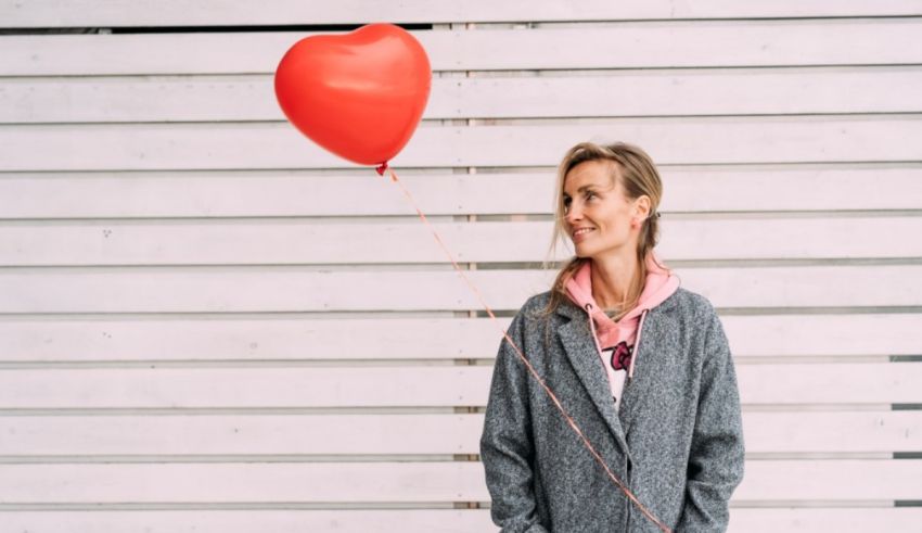 A woman holding a red balloon.