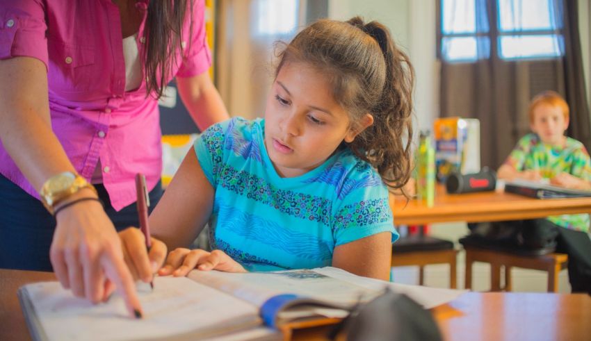 A teacher helping a young girl with her homework.