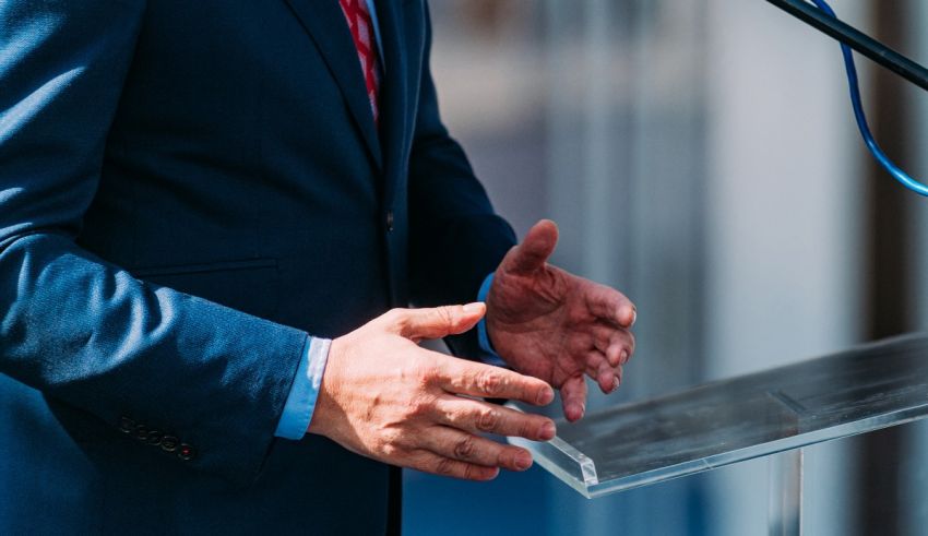 A man in a suit is giving a speech at a podium.