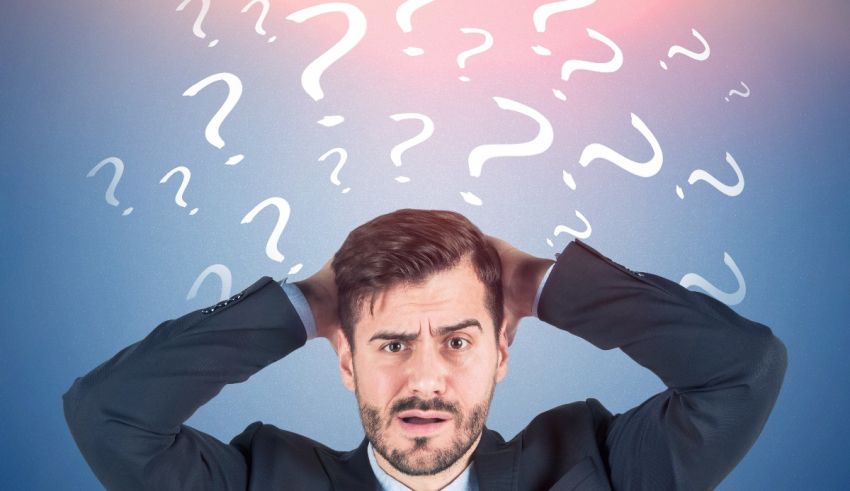 A businessman with question marks over his head.