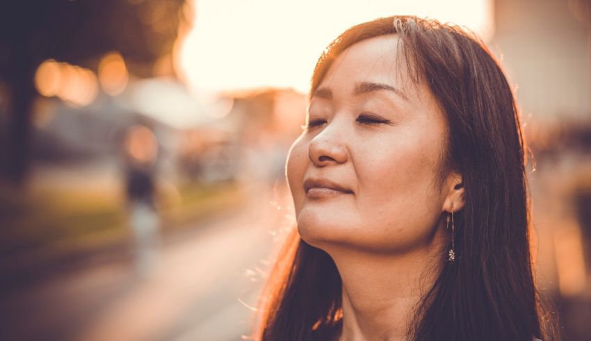 A woman is looking up at the sunset.