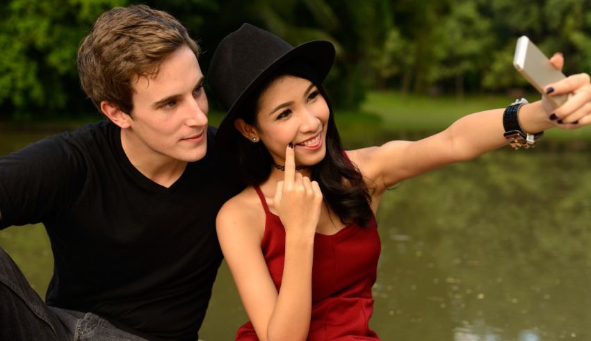 A man and woman taking a selfie in a park.