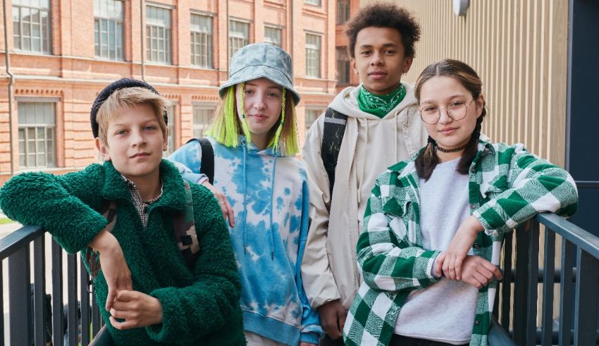 A group of young people standing on a railing.