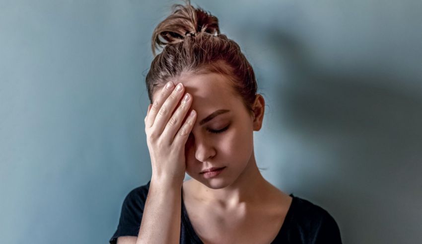 A woman is holding her head with her hands.