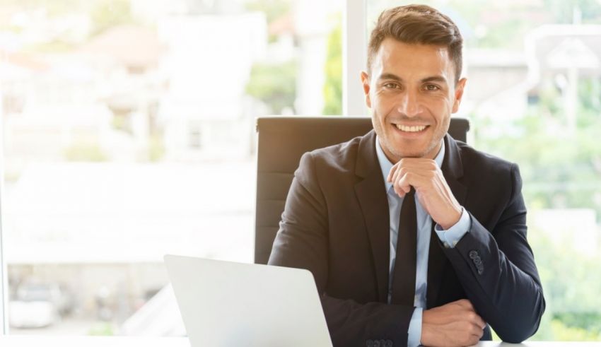 A businessman sitting at a desk with a laptop.