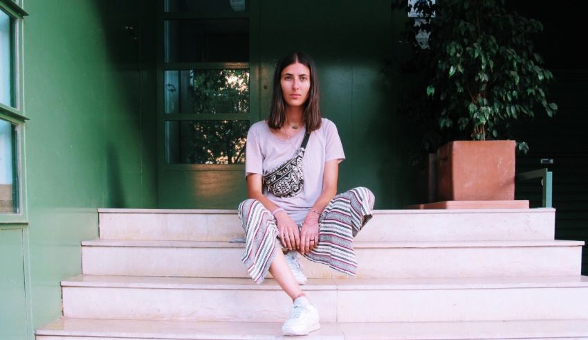 A woman sitting on steps with a bag.
