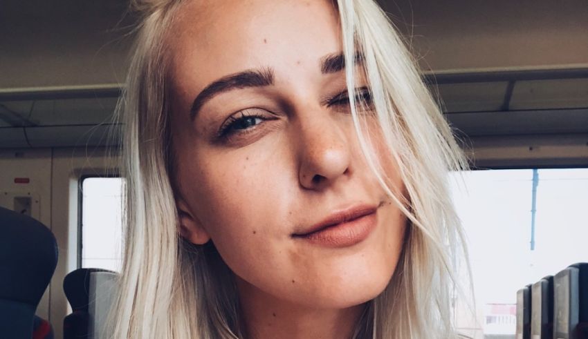 A woman with blonde hair is sitting on a train.