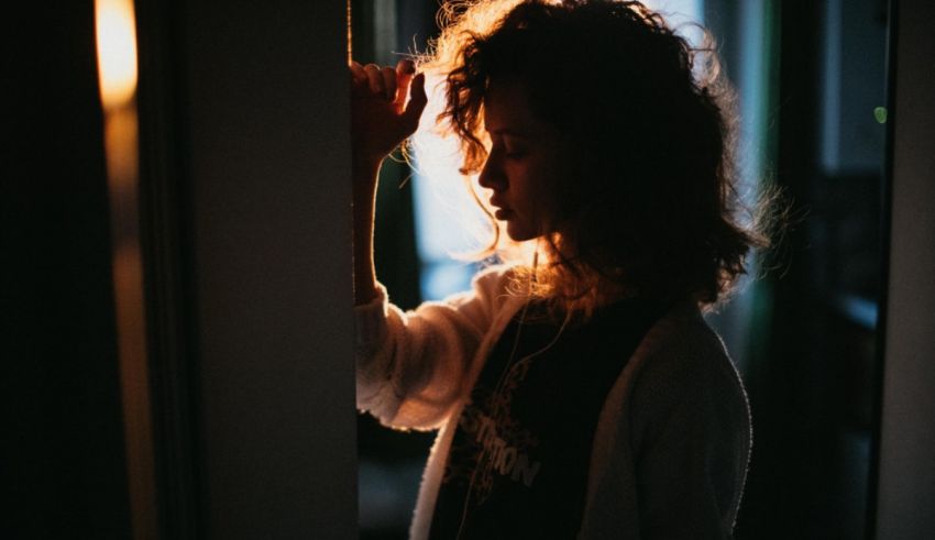 A woman is standing in front of a door.