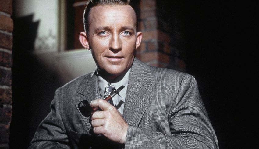 A man in a suit and tie is holding a pipe.