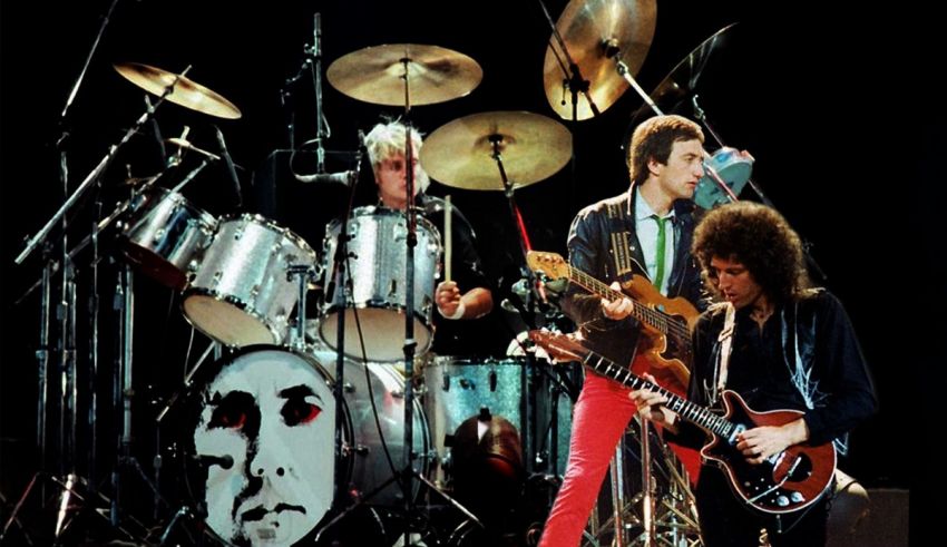 A group of people on stage with guitars and drums.