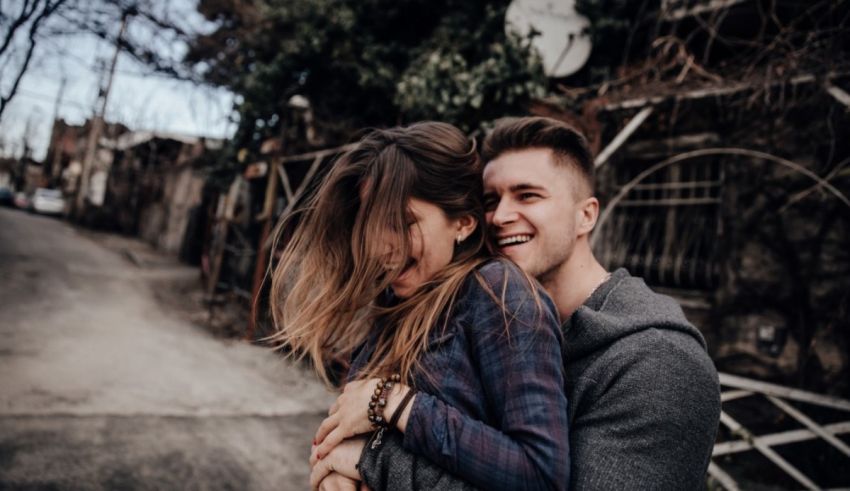 A man and woman hugging in the street.