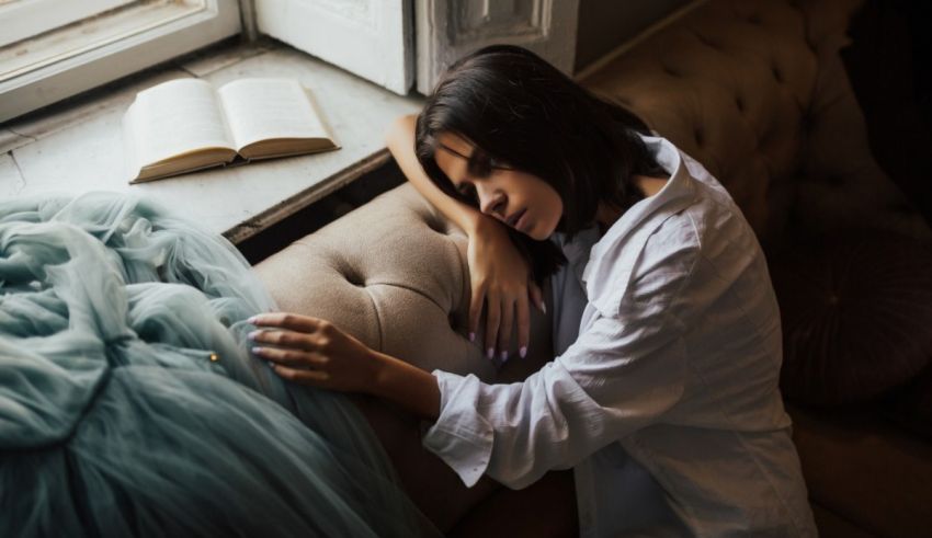 A woman is sleeping on a couch with an open book.