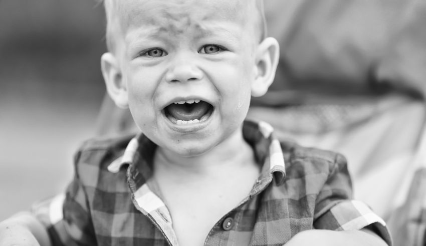 A black and white photo of a crying baby.