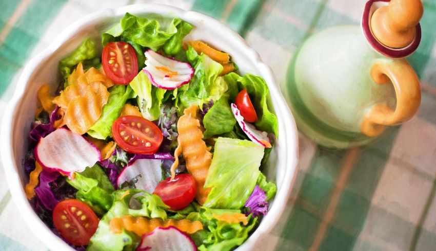 A salad with lettuce, tomatoes and radishes in a white bowl.