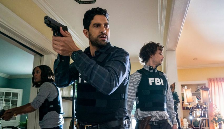 Two men in a room with a gun in their hands.