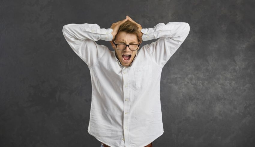 A man in glasses is holding his hands up in the air.