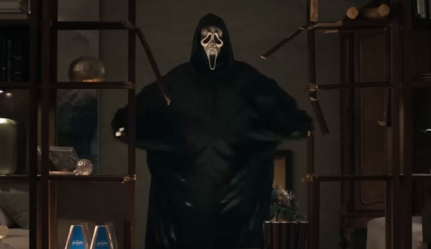 A man in a hooded robe is standing in a room.