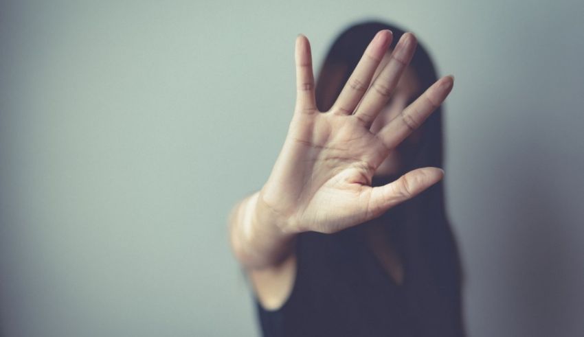 A woman is making a stop sign with her hand.