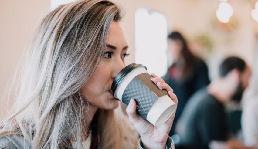 A woman drinking coffee in a coffee shop.