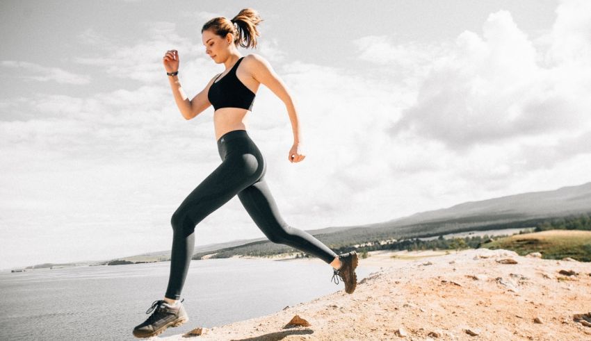 A young woman is running on a cliff near the ocean.