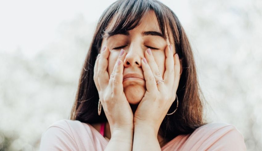 A woman covering her eyes with her hands.
