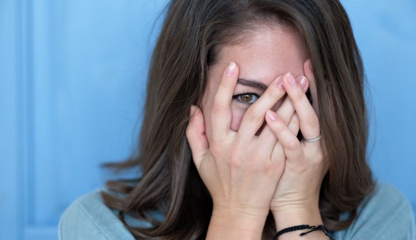 A woman covering her face with her hands.