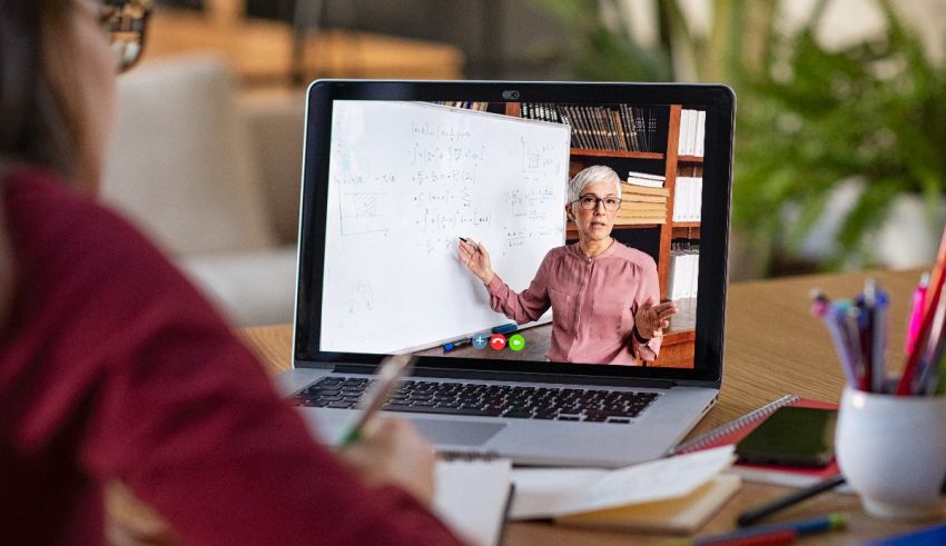 A woman is using a laptop to draw on a whiteboard.