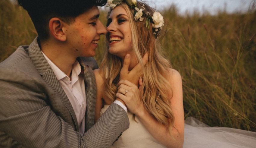 A bride and groom hugging in a field.
