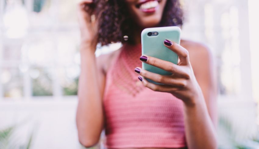 A woman with curly hair holding a cell phone.