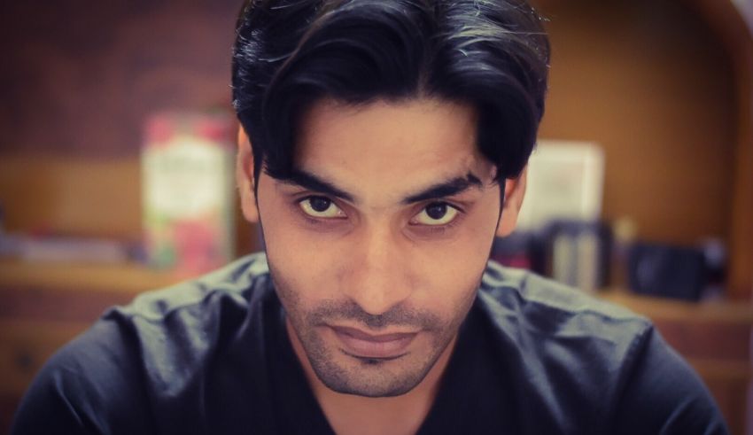 A man in a black shirt is staring at the camera.