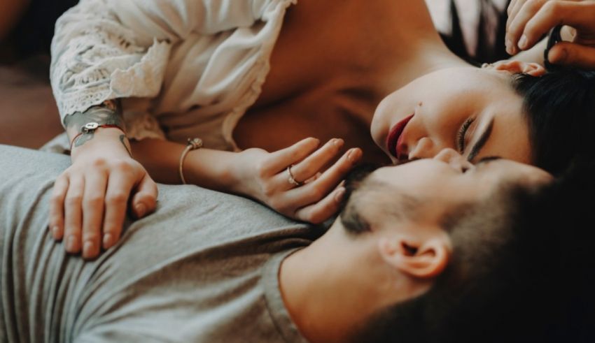 A man and woman laying on a bed together.