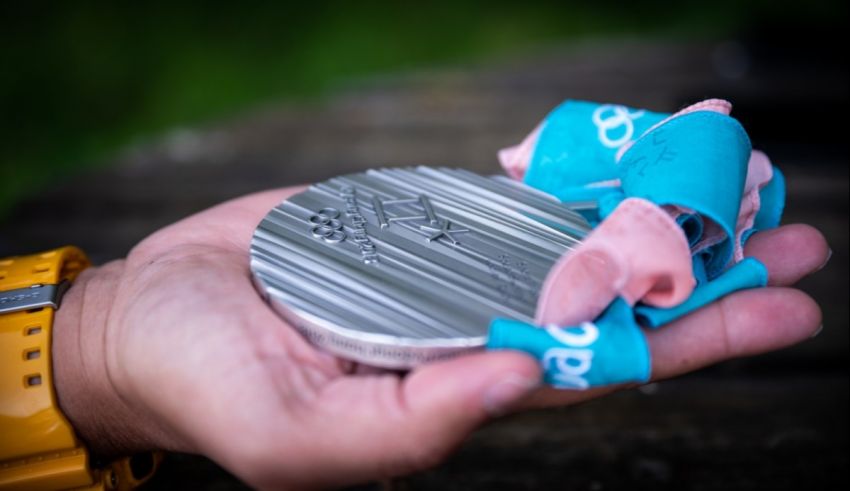 A person holding a silver medal in their hand.