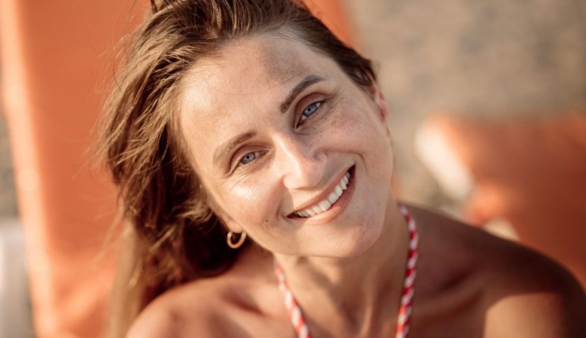 A smiling woman sitting on a beach chair.