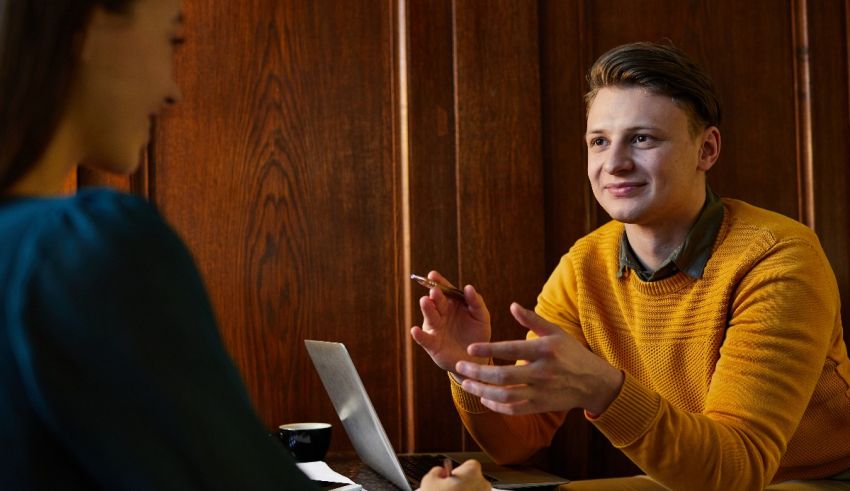 A man is talking to a woman in a coffee shop.