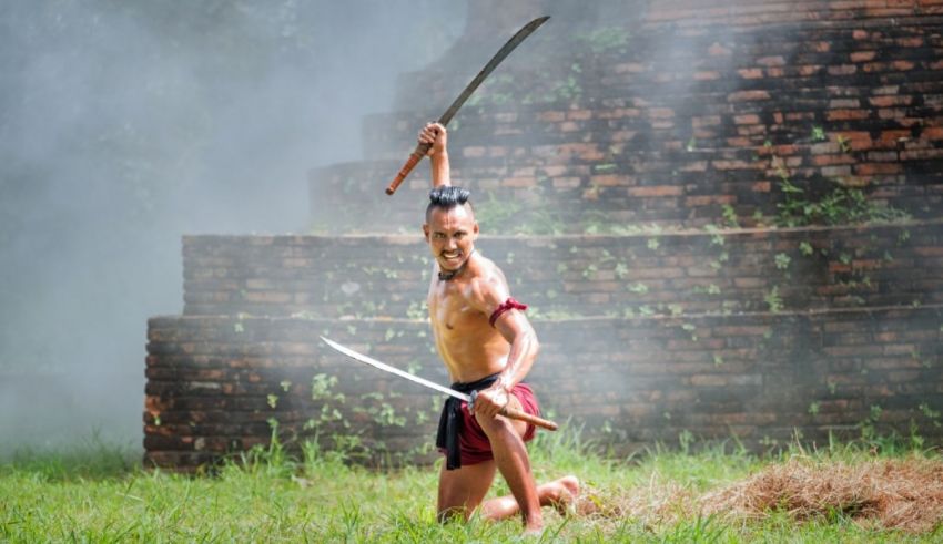 A man with two swords in the grass.