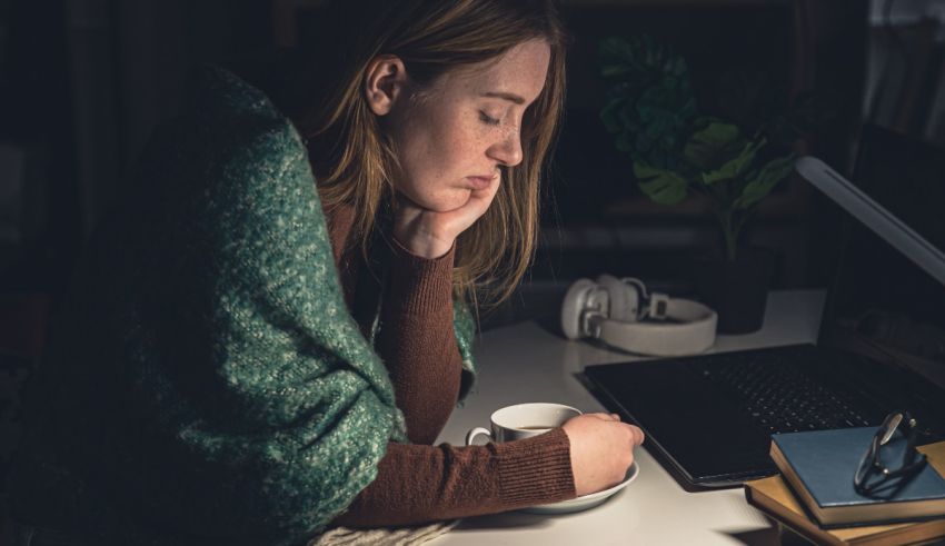 A woman is sitting at her desk with a cup of coffee.