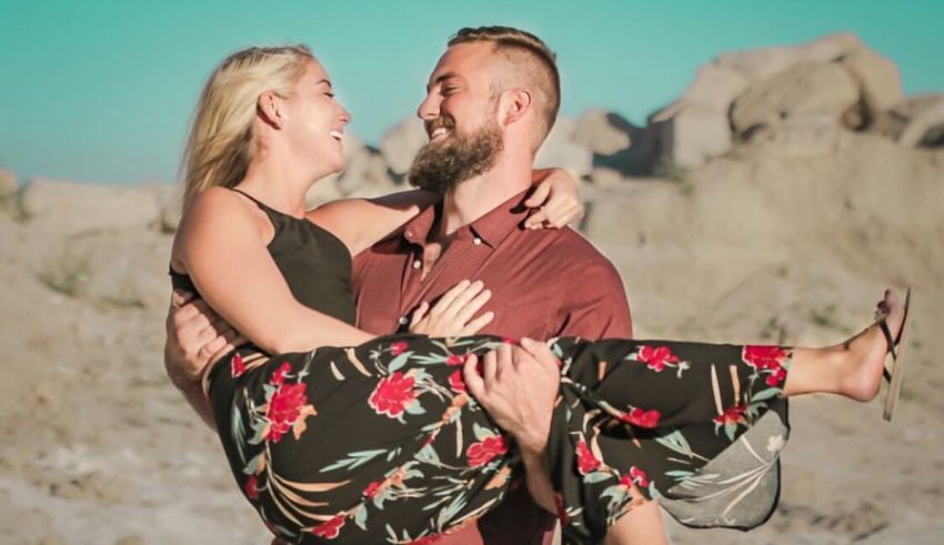 A man and woman are holding hands in the desert.