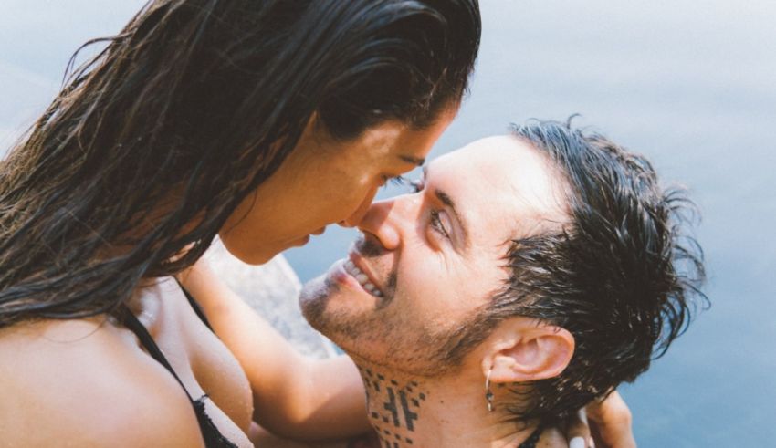 A man and woman kissing in the water.