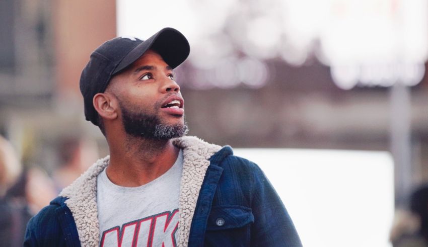 A man in a hat looking up at the sky.