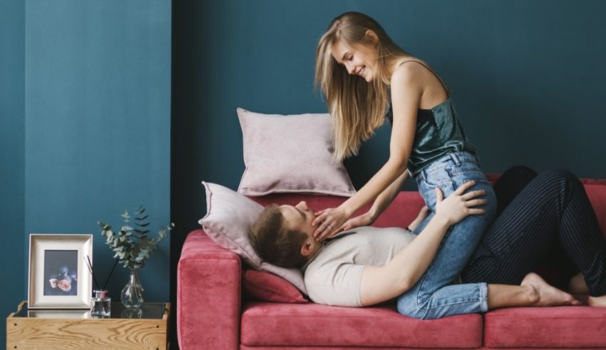 A man and woman sitting on a couch in a living room.